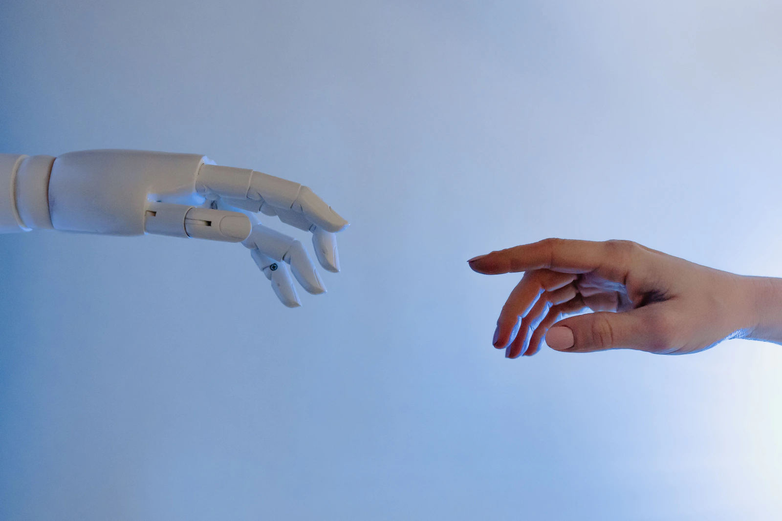 Eine Roboterhand und eine menschliche Hand greifen aufeinander zu